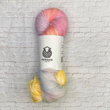 Load image into Gallery viewer, Multicolored skein of yarn with a Fergus label on a white brick background