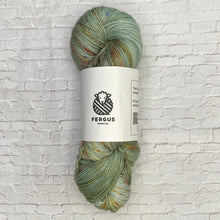 Load image into Gallery viewer, Green skein of yarn with a Fergus label on a white brick background