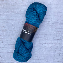 Load image into Gallery viewer, Blue skein of yarn with a label on a textured white background