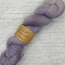 Load image into Gallery viewer, Purple skein of yarn with a label on a textured white background
