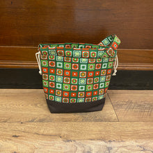 Load image into Gallery viewer, Green and red patterned bag on a wooden floor with a wooden wall background
