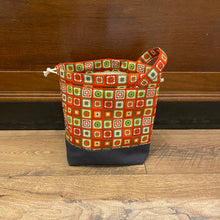 Load image into Gallery viewer, Patterned bucket bag on a wooden floor with a wooden wall background
