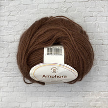 Load image into Gallery viewer, Brown yarn ball with Amphora label on a white brick wall background
