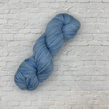 Load image into Gallery viewer, Blue skein of yarn on a white brick wall background
