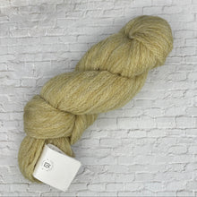 Load image into Gallery viewer, Ball of green yarn with a label on a light gray brick-patterned background
