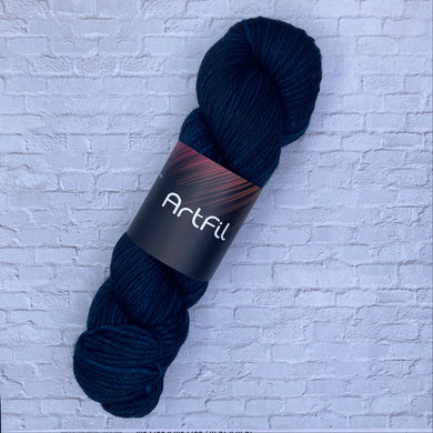 Dark blue skein of yarn with a label on a textured white background