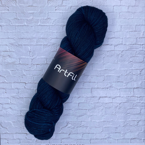 Dark blue skein of yarn with a label on a textured white background