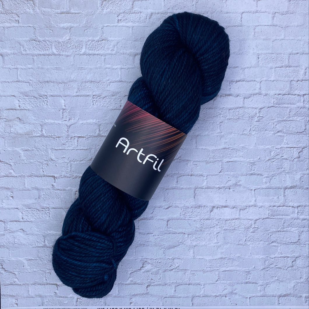 Dark blue skein of yarn with a label on a textured white background