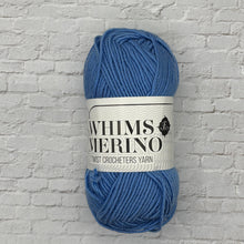 Load image into Gallery viewer, Blue yarn ball with a label on a textured gray background
